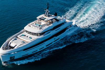 A sleek white yacht glides through the deep blue ocean, leaving a white wake in its path.