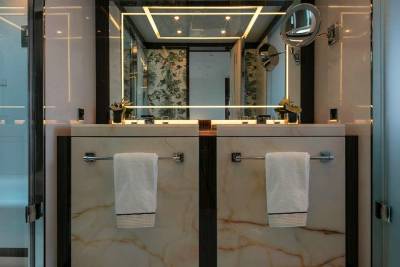 Luxurious marble vanities and a sleek glass shower create an opulent retreat in this modern bathroom.