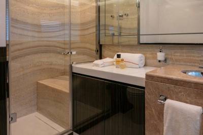 Luxurious marble and glass create a serene spa-like atmosphere in this elegant bathroom.