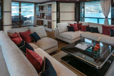 Plush sofas and a chic coffee table create a luxurious lounge space aboard this yacht, with stunning ocean views.
