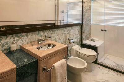 Luxurious marble and botanical wallpaper create an elegant and serene atmosphere in this sophisticated bathroom.