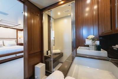 Luxurious wood paneling and a sleek glass shower define this opulent yacht bathroom.