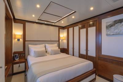 Luxurious yacht cabin features a plush bed, elegant wood accents, and ambient lighting for ultimate comfort at sea.