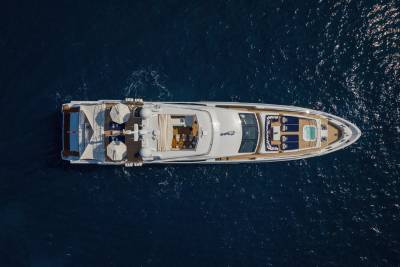 A luxurious yacht glides through the deep blue sea, offering a serene escape with its elegant decks and inviting jacuzzi.