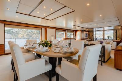 A beautifully appointed dining room on a yacht offers a formal setting for meals with a stunning ocean view.