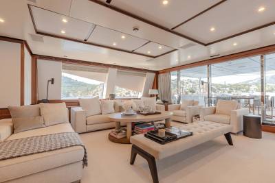 Luxurious yacht interiors blend seamlessly with breathtaking coastal views through expansive windows.