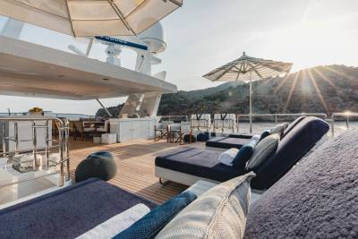 Luxurious sun loungers await on a yacht's deck, bathed in the warm glow of a Mediterranean sunset.