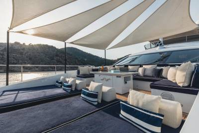 Luxurious yacht deck seating offers a serene spot to enjoy the sun-drenched coastal scenery.