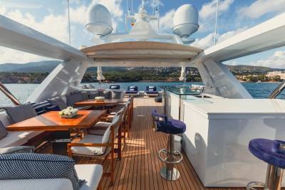 Luxurious yacht deck seating and a bar offer a perfect spot for enjoying the Mediterranean scenery.