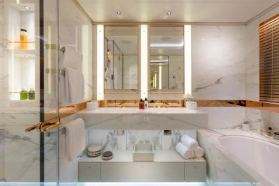 Luxurious marble bathroom features a double vanity, a glass-enclosed shower, and a deep soaking tub.