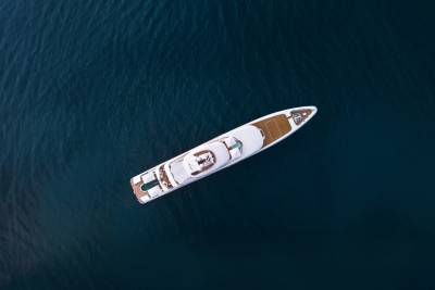 A luxurious white yacht glides across the deep blue ocean, showcasing its elegant design and spacious decks.