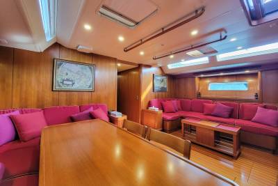 Luxurious red upholstery and rich wood paneling create a warm and inviting atmosphere in this yacht's spacious salon.