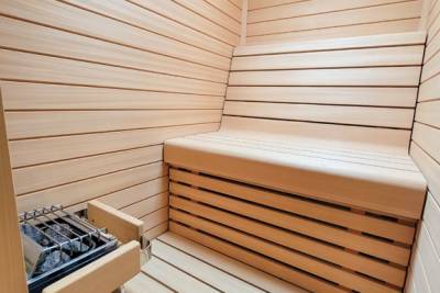 Relax and unwind in this beautifully crafted wooden sauna, complete with a modern Harvia heater.