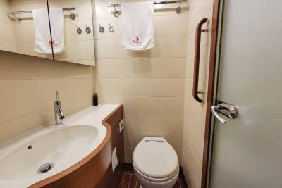 A compact, modern bathroom features a sleek sink, toilet, and shower with polished chrome fixtures.