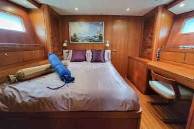Luxurious wood paneling and plush bedding create a serene retreat aboard this elegant yacht.