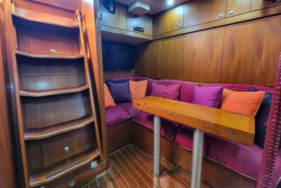 A cozy, wood-paneled salon with plush seating and a fold-down table offers a comfortable retreat.