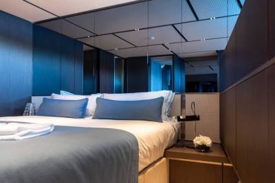 Luxurious blue accents and mirrored ceilings create a serene and spacious atmosphere in this elegant bedroom.