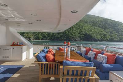 Relax on the spacious deck of this luxury yacht, surrounded by lush green hills and the sparkling blue sea.