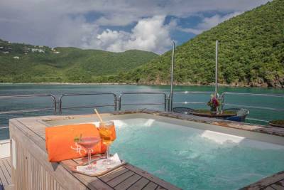 Relax in the bubbling hot tub with tropical cocktails and a stunning view of lush green islands.