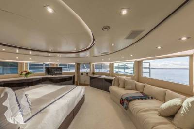 Luxurious yacht interiors offer stunning ocean views from a plush sectional sofa and a comfortable king-sized bed.
