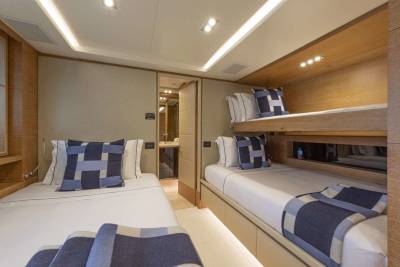 Bunk beds and a twin bed offer comfortable sleeping arrangements in this stylish yacht cabin.