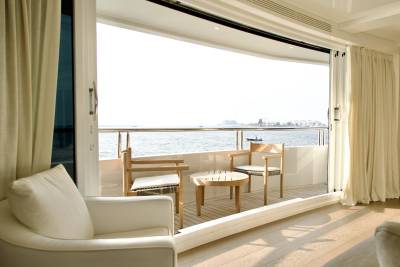 Enjoy breathtaking ocean views from this luxurious yacht's private balcony, complete with comfortable seating.