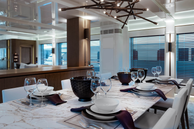 A modern dining table is set for a formal meal with elegant place settings and a striking centerpiece.