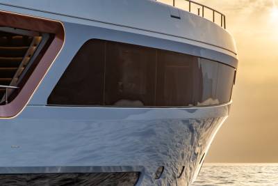 The sleek lines of a luxury yacht reflect the golden hues of a serene sunset over the calm ocean.