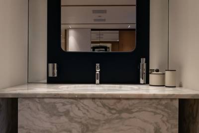 A sleek marble vanity with a modern faucet and minimalist accessories creates a luxurious bathroom oasis.