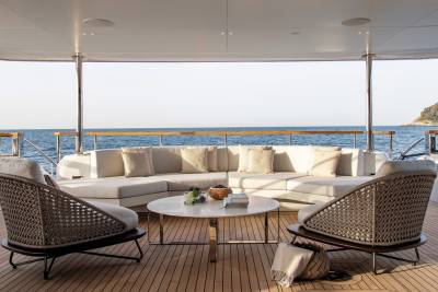 Relax on the spacious deck of this luxury yacht, surrounded by the serene blue ocean and lush green coastline.