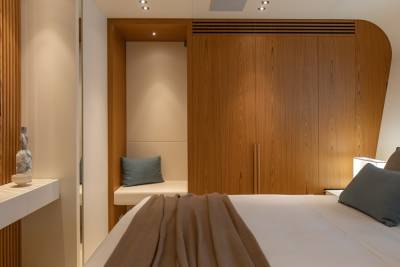 A cozy bedroom features a built-in bench, ample wood cabinetry, and a comfortable bed adorned with plush pillows and a warm throw.