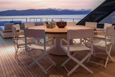Dine al fresco on this luxurious yacht deck as the sun sets over the tranquil water.