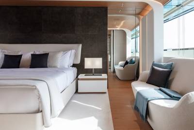 Luxurious modern yacht interiors feature a spacious bedroom and a cozy seating area with stunning ocean views.