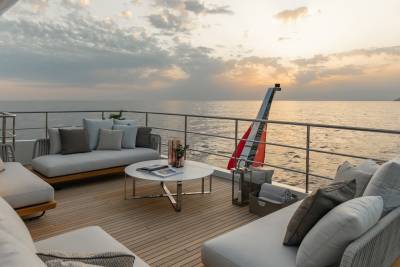 Enjoy a serene sunset cruise from the luxurious deck of this yacht, complete with comfortable seating and elegant decor.