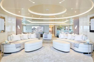 Luxurious white sofas create a serene seating area within this elegantly designed yacht salon.