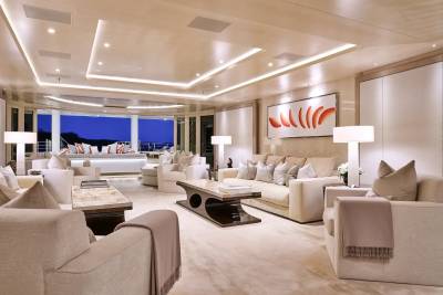 Luxurious yacht salon offers plush seating and panoramic views of the twilight ocean.