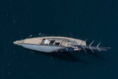 A sleek, modern yacht glides through the deep blue ocean, its sails catching the sunlight.