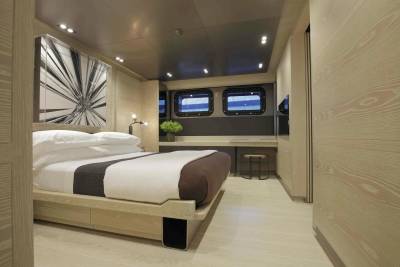 Luxurious yacht interiors feature a serene bedroom with crisp white linens and modern art.