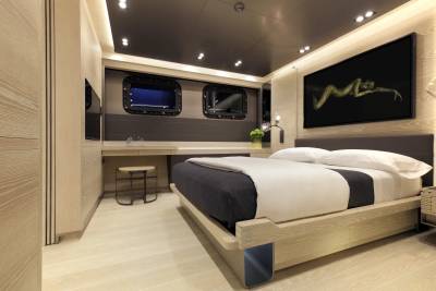 Luxurious yacht cabin features a minimalist design with a comfortable bed and striking artwork.