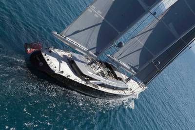 A majestic sailing yacht glides through the turquoise ocean under full sail.