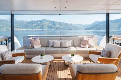 Relax on the luxurious deck of a yacht, surrounded by stunning mountain and sea views.