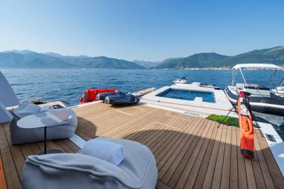 Relax on the spacious deck of a luxury yacht, surrounded by stunning mountain scenery and crystal-clear waters.