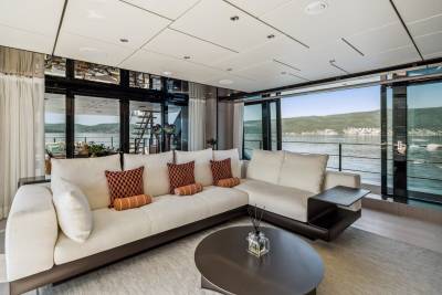 Luxurious yacht interiors offer breathtaking views of the serene bay and lush green hills.