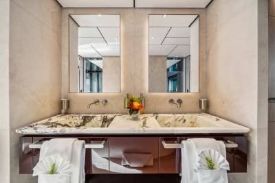 A luxurious double vanity with marble countertops and plush towels creates an elegant bathing space.