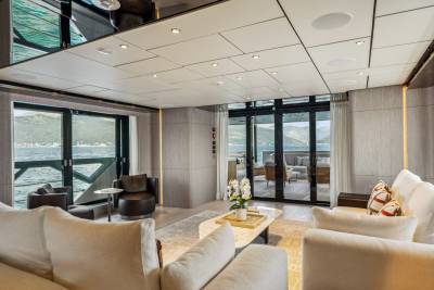 Luxurious yacht interiors seamlessly blend with breathtaking ocean views through expansive glass doors.