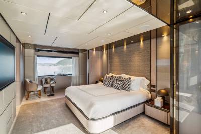 Luxurious yacht stateroom offers serene sea views and elegant comfort with a plush bed and stylish seating.