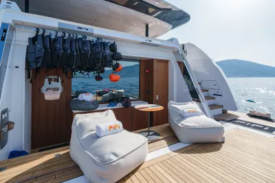 Relax in comfort on the deck of this luxurious yacht, surrounded by the sparkling blue sea and distant green hills.