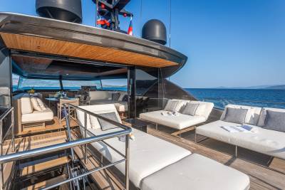 Luxurious white lounge chairs and seating areas adorn the deck of this yacht, offering a perfect spot to relax at sea.