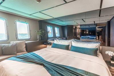 Luxurious yacht cabin offers serene ocean views from comfortable berths and plush seating.