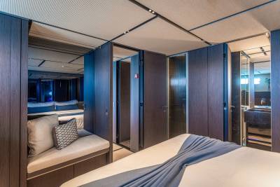 Luxurious dark wood paneling and plush seating create an opulent retreat within this modern yacht cabin.